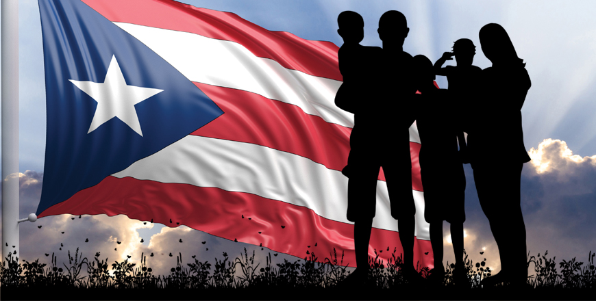 Silhouette of a family standing in front of Puerto Rico's flag. 