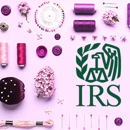 Lilac background; large green IRS logo; sewing notions in tones of purple (thread, bobbin, buttons, pins, flowers, pin cushion)