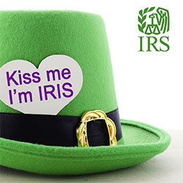 Green top hat with a paper heart tucked in band that reads Kiss me I’m IRIS. Green IRS logo.