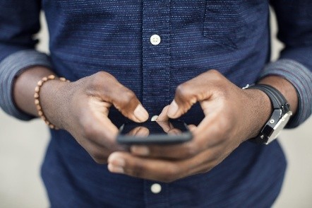 Gwo plan sou yon moun k ap itilize yon telefòn mobil